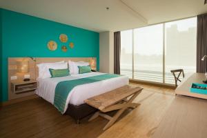 巴兰基亚BH巴兰基亚酒店的一间卧室设有一张大床和绿色的墙壁
