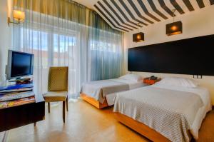 里斯本雷亚尔普林西比酒店的酒店客房设有两张床和电视。