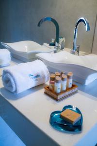 钦博特Hotel Maresta Lodge - Hotel Asociado Casa Andina的浴室柜台配有水槽、毛巾和一瓶药品