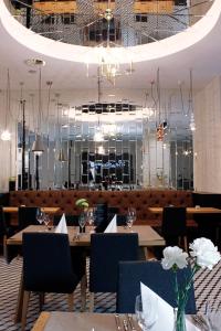 拉多姆Hotel Nihil Novi的一间带桌椅和吊灯的餐厅