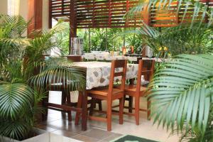清莱温灿迪酒店的一间设有桌椅和植物的餐厅