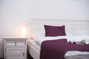 斯维塔维Hotel Slavia的床头柜旁的白色床和紫色枕头