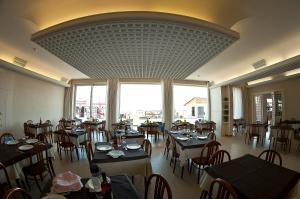 贝拉里亚-伊贾马里纳阿尔巴德奥罗酒店的餐厅设有桌椅和大窗户。