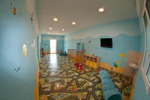 贝拉里亚-伊贾马里纳阿尔巴德奥罗酒店的一间设有幼儿园的房间,里面配有婴儿床和地毯