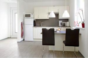 柏林贝立兹公寓的厨房配有白色冰箱和2把椅子
