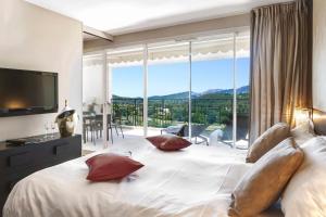 穆然皇家穆冉高尔夫豪华酒店及Spa的一间卧室设有一张大床和大窗户