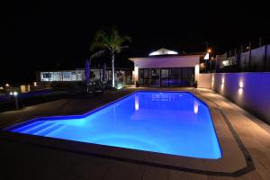 奥尔巴尼艾米蒂乡村舒适汽车旅馆的夜间游泳池与房子