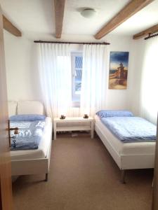 古梅尔斯巴赫历史公寓的一间卧室设有两张床和窗户。