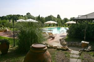 福利亚Casa Terra Rossa的后院设有游泳池和带遮阳伞的庭院。