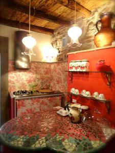 内米Vistalago Guesthouse的厨房设有红色的墙壁和一张桌子及锅碗瓢盆