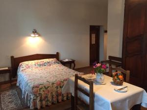 旺斯阿博格领主酒店的一间卧室配有一张床和一张桌子及两把椅子