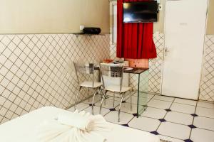 累西腓恩里克·迪亚斯（仅限成人）情趣酒店和汽车旅馆的一间卧室配有一张床、两把椅子和电视