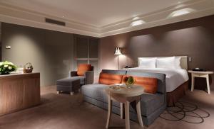 新竹新竹老爺酒店的配有一张床和一把椅子的酒店客房