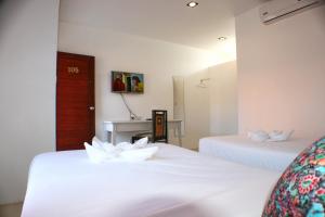 高兰浓杜莱宾馆的一间设有两张白色鲜花的床的房间