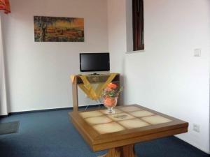 绍纳赫Landhaus Panoramablick的一间设有桌子的客房,墙上配有电视