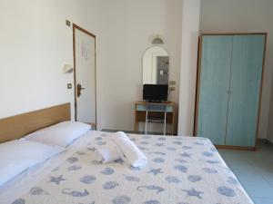 里米尼双子酒店的一间卧室配有一张床,床上有毛巾