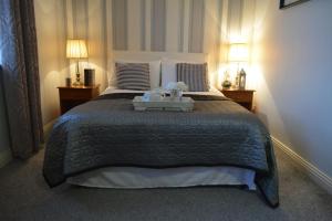 利默里克伍德菲尔德之家酒店的一间卧室配有一张大床,上面有托盘