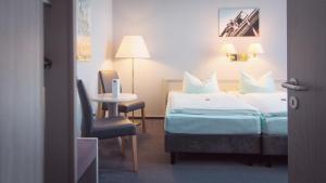 波鸿波鸿伊克赛尔瑟酒店的酒店客房,配有床、桌子和椅子