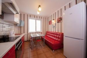 克拉斯诺亚尔斯克Apartment Vesnu 17的厨房配有红色的沙发和红色的椅子