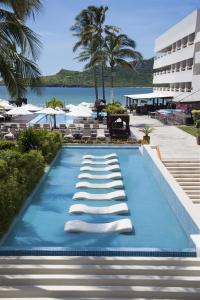 马萨特兰马萨特兰帝王酒店&度假村的一个带躺椅的游泳池,一个度假村