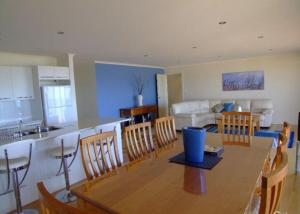 Emu Bay鸸鹋湾埃拉诺拉宁谧度假屋的厨房以及带桌椅的起居室。