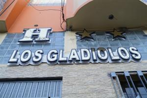 卡哈马卡Hotel Los Gladiolos的建筑物一侧的los funios标志