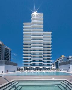 迈阿密海滩Ocean 2 Sky at Monte Carlo Miami Beach的一座高大的建筑,前面有一个游泳池