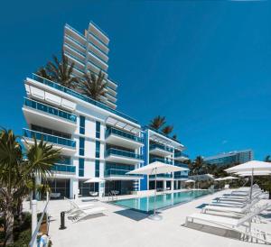 迈阿密海滩Ocean 2 Sky at Monte Carlo Miami Beach的一座带游泳池和遮阳伞的建筑的图片