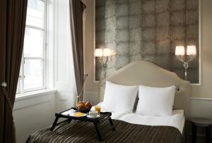 哥本哈根哥本哈根凤凰酒店的一间酒店客房,配有一张带托盘的床