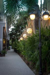 蔻立拷叻MJ精品旅舍的一条有植物的人行道旁的路灯