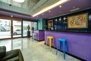高雄礼来大饭店的餐厅内带蓝色和黄色凳子的紫色酒吧