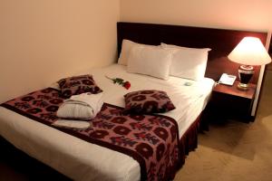 塔什干乌兹别克斯坦酒店的酒店客房配有带灯具和毛巾的床。