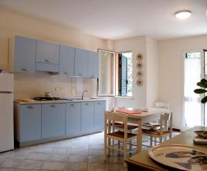 圣温琴佐Residence Loggetta Margherita的厨房配有蓝色橱柜和桌子