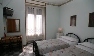米兰艾娃酒店的一间卧室配有两张床、一张桌子和一台电视。