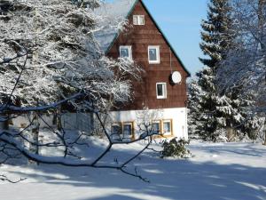 库罗阿尔滕堡豪斯畔塔可旅馆的一座大木房子,在雪中,有树木