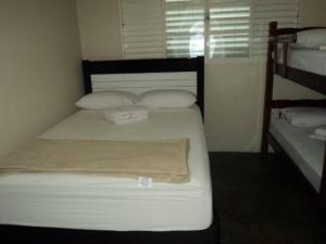 奥林匹亚Pousada Keluz的卧室配有白色的床和2个枕头