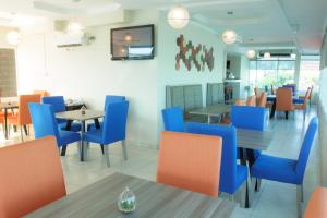 巴拿马城巴伊亚套房酒店的餐厅设有蓝色和橙色的椅子和桌子