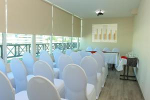 巴拿马城巴伊亚套房酒店的一间会议室,配有白色的椅子和桌子