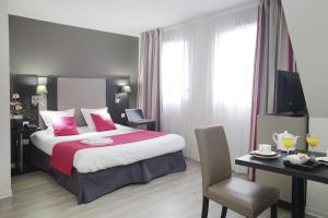 斯特拉斯堡斯特拉斯堡奥德利斯绿沼泽公寓式酒店的酒店客房带一张大床以及一张桌子和椅子。