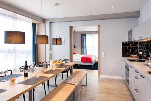 慕尼黑慕尼黑MLOFT公寓式酒店的厨房以及带木桌和椅子的用餐室。