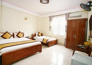 奠边府市宝安酒店的一间卧室设有两张床和窗户。