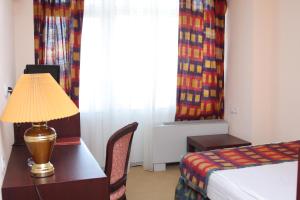 塔什干乌兹别克斯坦酒店的酒店客房配有一张床和一张带台灯的书桌