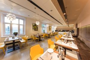 布达佩斯维多利亚经济型酒店的用餐室配有桌子和黄色椅子