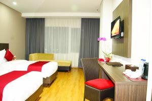 贝克西Merapi Merbabu Hotels Bekasi的配有一张床和一张书桌的酒店客房