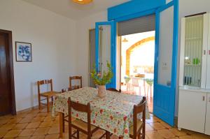 帕图Casa Orizzonte的一间用餐室,配有一张桌子和花瓶