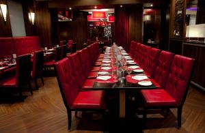 埃德蒙顿幻想世界酒店的餐厅里一张长桌子和红色椅子