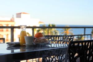 坎布里尔斯Apartamentos Cambrils Playa Spa的餐桌,茶几,咖啡和一盘食物