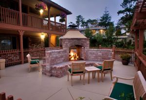 卡梅尔烛光酒店的庭院设有砖砌壁炉、椅子和桌子