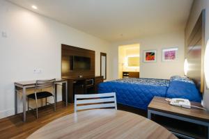 休斯顿蓝城中心宫殿汽车旅馆的配有一张床、一张桌子和一张桌子的酒店客房