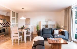 杜塞尔多夫帕克赛德公寓的客厅以及带沙发和桌子的厨房。